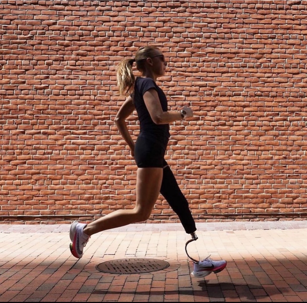 Adrianne Haslet running beside a brick wall