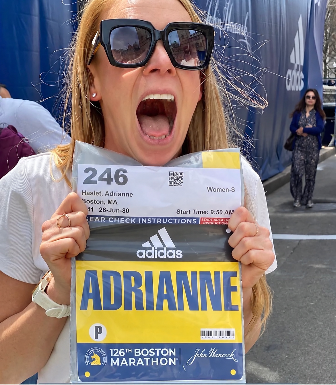 Adrianne Haslet holding her Boston Marathon bib